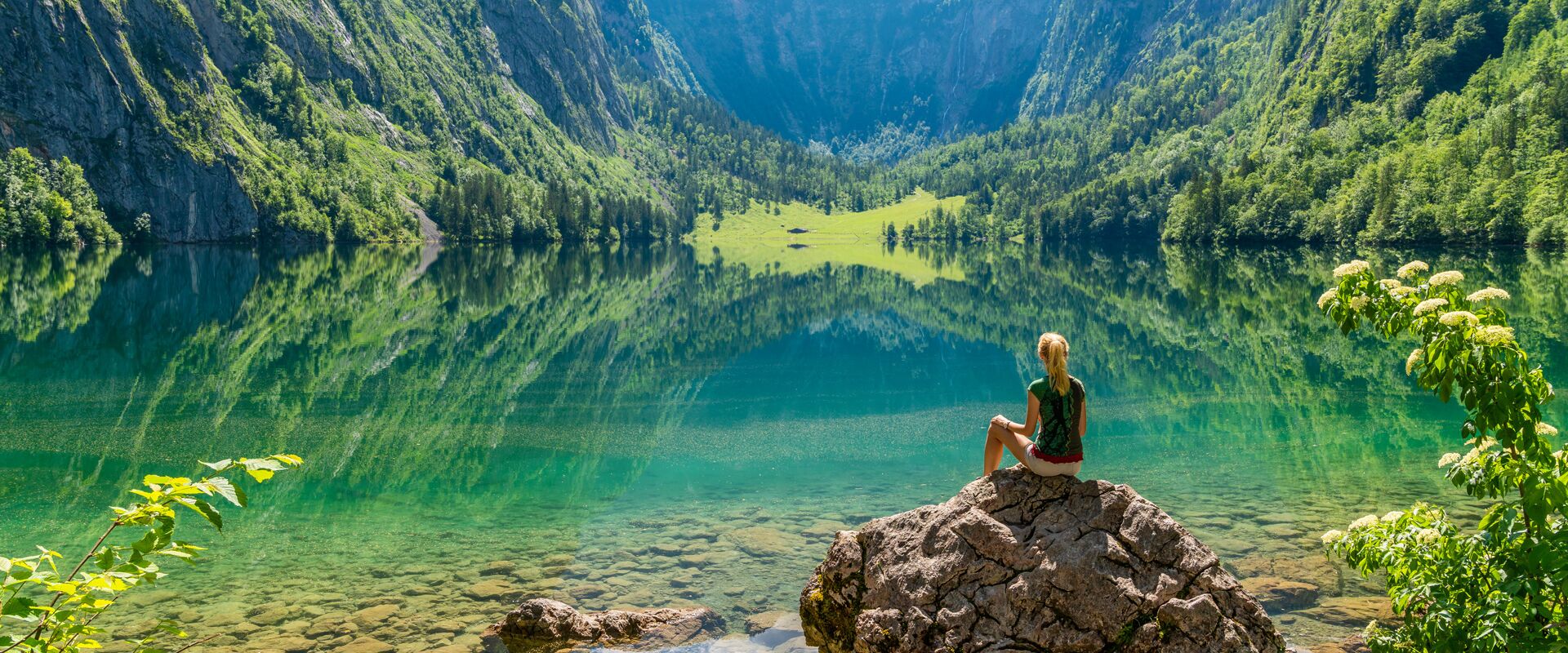 Frau auf Stein im blauen See